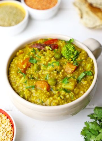 side shot of vegetable millet khichdi in a glass mug