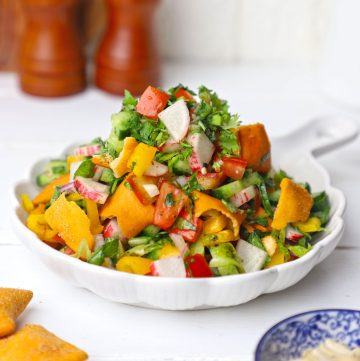 side shot of fattoush salad stacked on a white platter