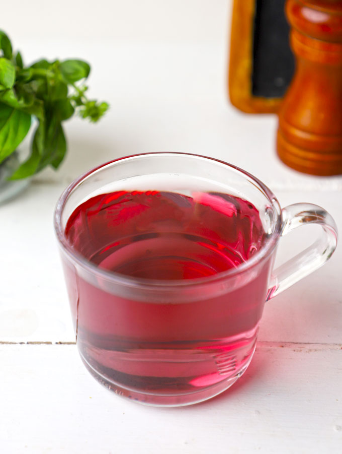 side shot of warm hibiscus tea in a glass mug