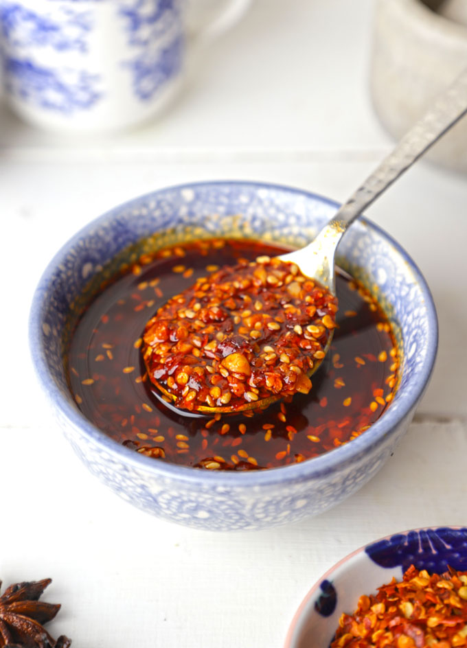 side angle shot of chilli oil in a blue ceramic bowl with the spoon