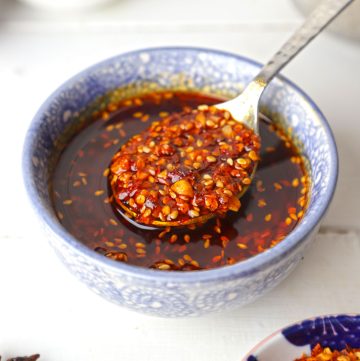 aerial shot of chilli oil in a blue ceramic bowl with a spoon