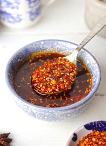 side angle shot of chilli oil in a blue ceramic bowl with the spoon