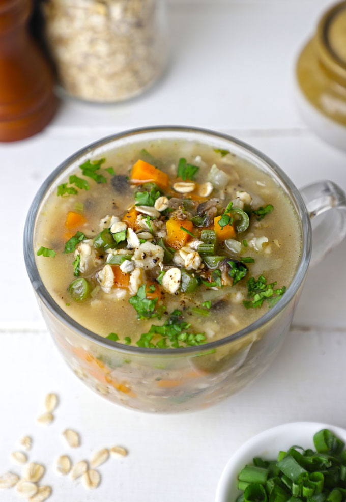 side shot of vegetable oats soup in a glass mug
