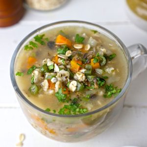 side shot of vegetable oats soup in a glass mug