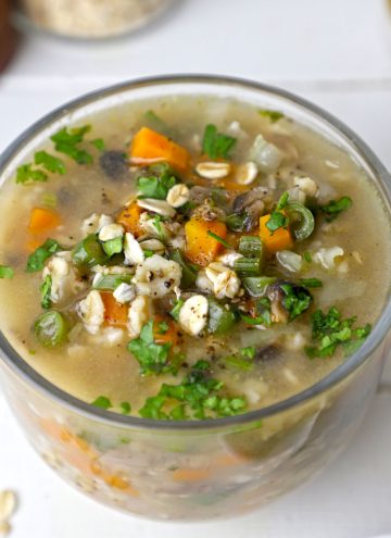 side shot of vegetable oats soup in a glass mug
