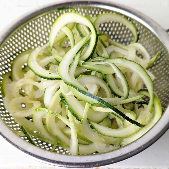 close up shot of Zucchini Noodles in a metal colander
