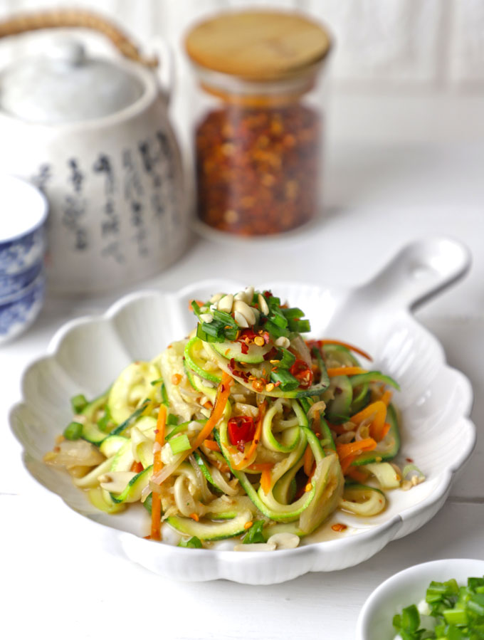 side shot of stir fry zoodles in a white ceramic platter