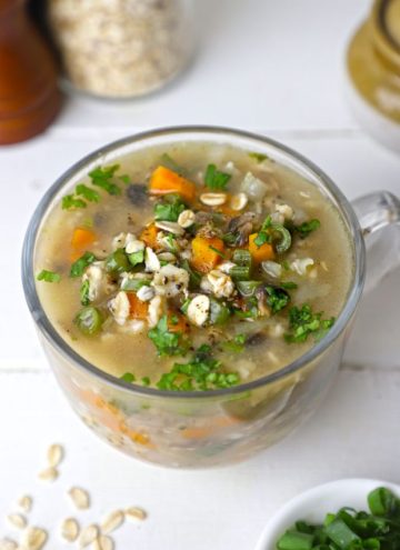 side shot of vegetable oats soup in a glass mug
