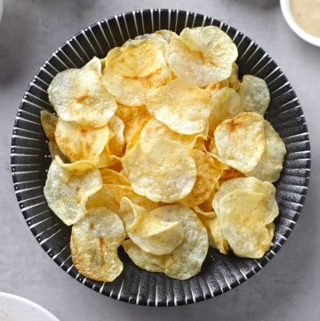 aerial shot of air fryer potato chips in a black bowl