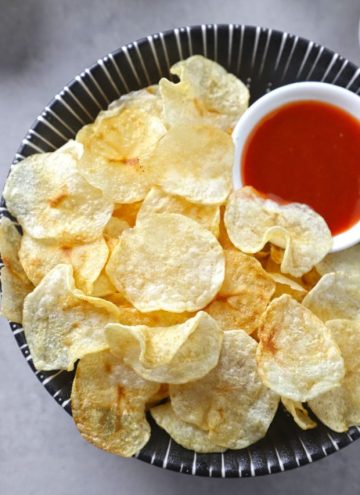 aerial shot of potato chips with ketchup in a bowl