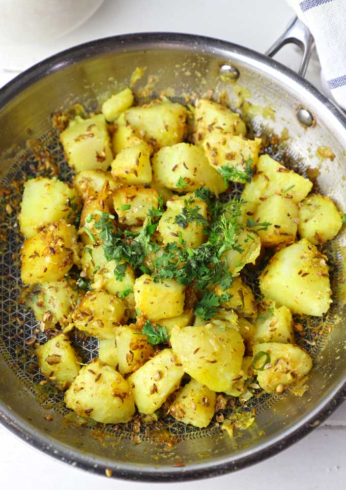 close up shot of jeera aloo in a frying pan