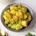 side close up shot of jeera aloo in a grey ceramic bowl