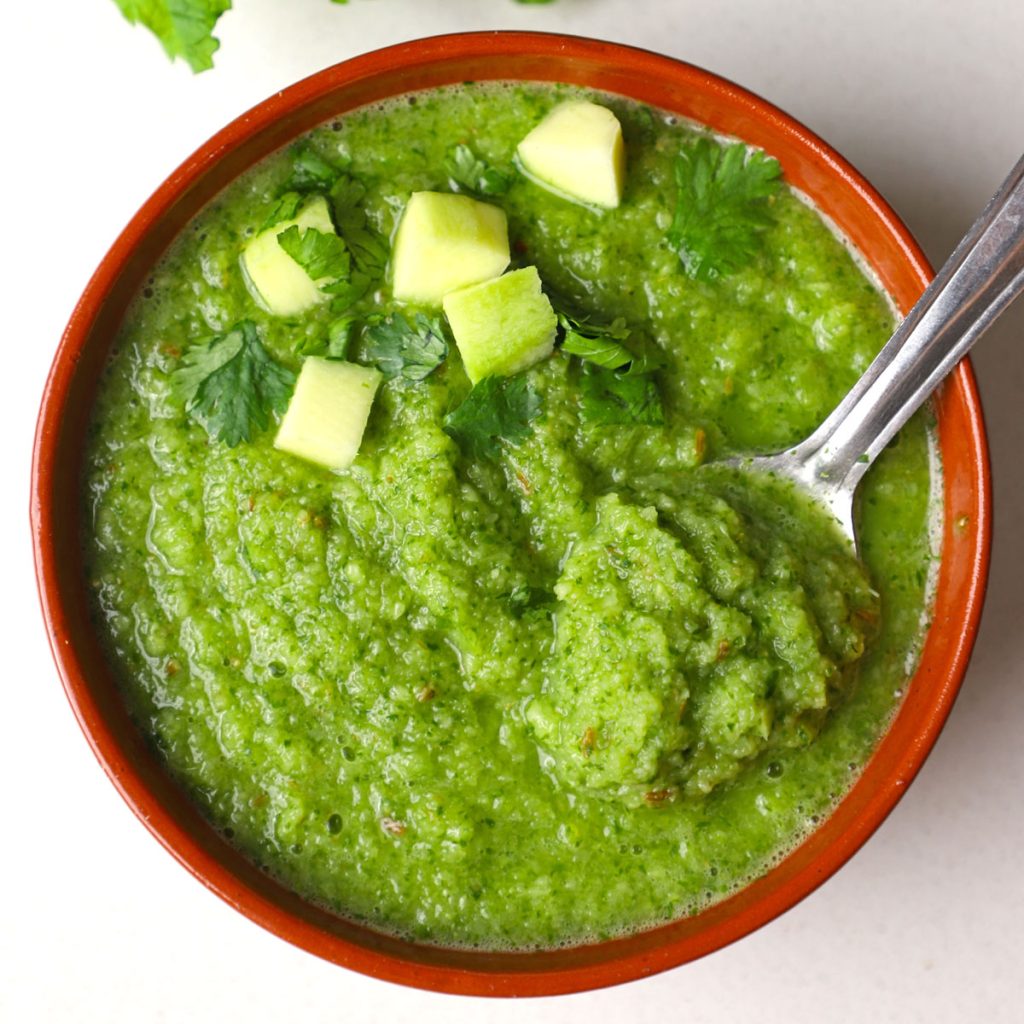 aerial shot of green mango chutney served in a brown bowl.