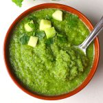 aerial shot of green mango chutney served in a brown bowl.