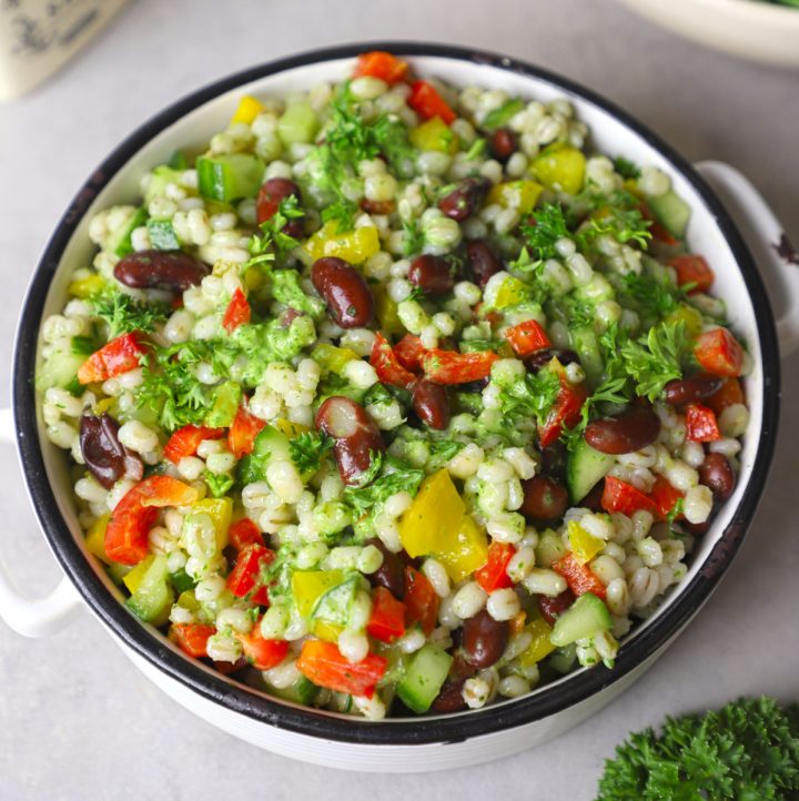 aerial shot of green barley salad in a white ceramic bowl