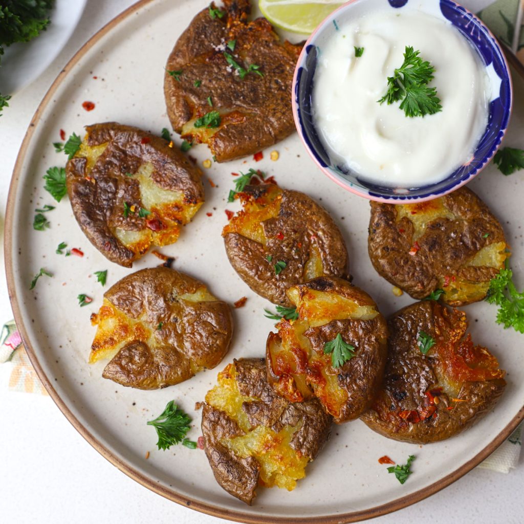 aerial shot of crispy smashed potato in a ceramic platter.