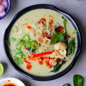 aerial shot of Thai green curry soup served in a black bowl.