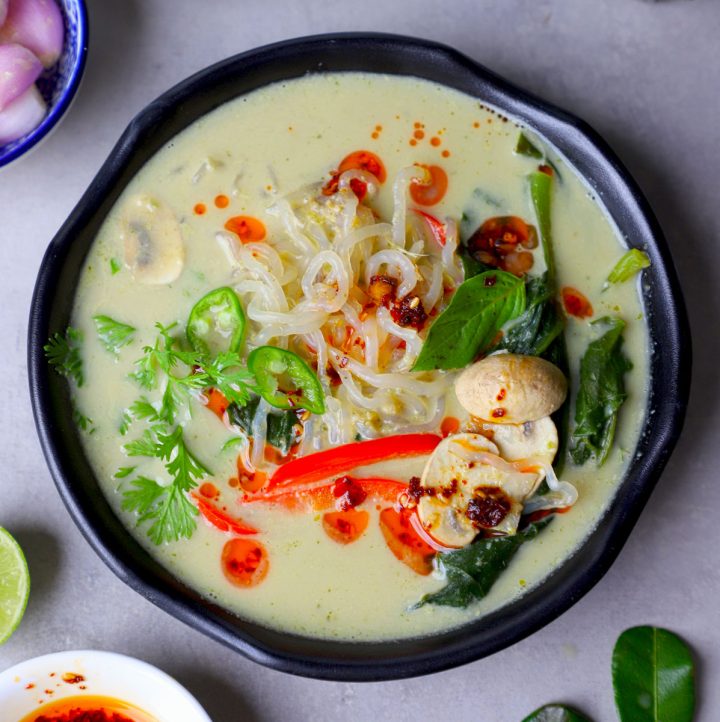 aerial shot of Thai green curry soup served in a black bowl.