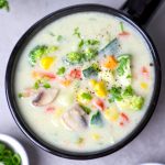 aerial shot of creamy vegetable soup in a black ceramic bowl