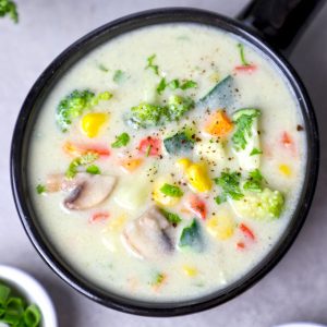 aerial shot of creamy vegetable soup in a black ceramic bowl