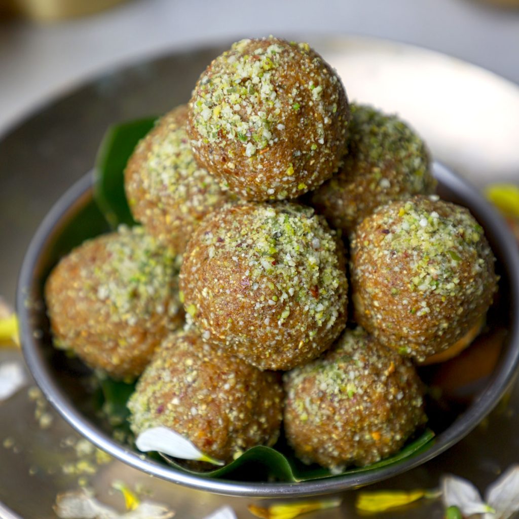 side close up shot of sattu ke laddu stacked in a stainless steel bowl.