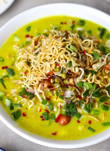 side close up shot of khao suey served in a white bowl.
