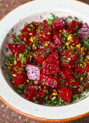 side close up shot of beetroot salad in a ceramic bowl.