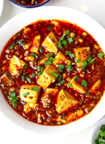 aerial shot of vegan mapo tofu served in a white ceramic bowl.