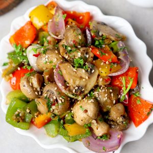 side close up shot of mushroom pepper fry served in a white ceramic plate. - 8