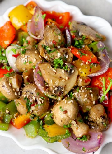 side close up shot of mushroom pepper fry served in a white ceramic plate.