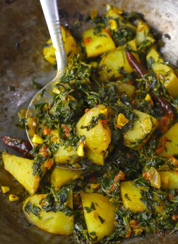 side close up shot of methi aloo in a cast iron kadhai.