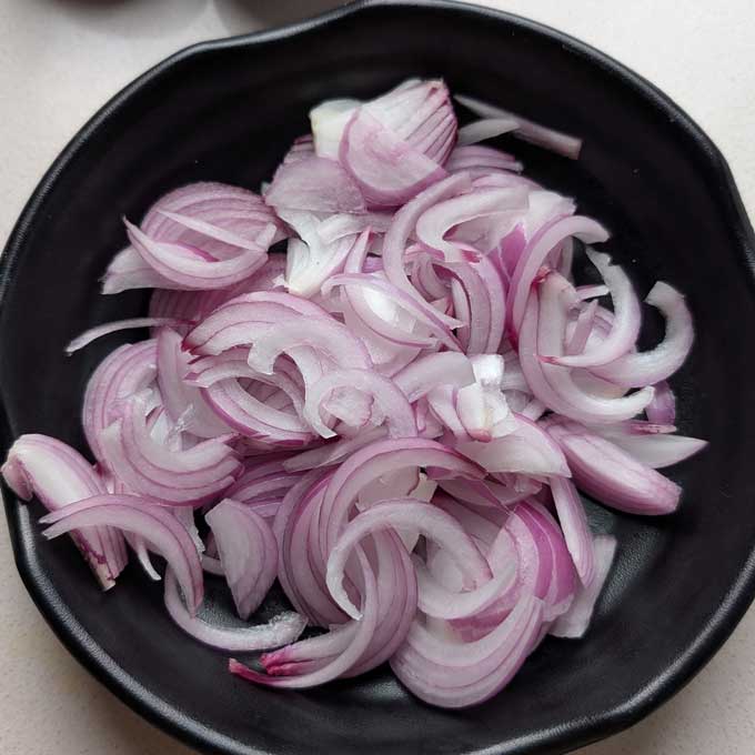 aerial shot of sliced red onion in a balck bowl. - 4