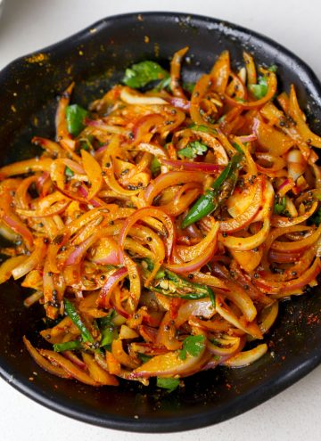 aerial shot of onion pickle served in a black bowl.