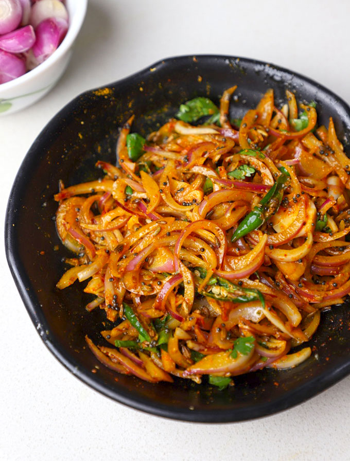 side close up shot of pyaz ka achar in a black ceramic bowl. - 1