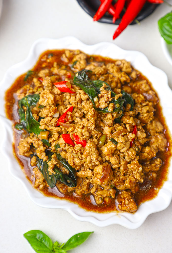 side close up shot of Thai basil chicken served in a white platter. - 7