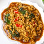 side close up shot of Thai basil chicken served in a white platter. - 11