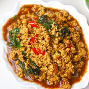 side close up shot of Thai basil chicken served in a white platter. - 16