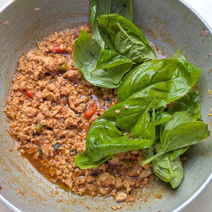 adding basil to Thai chicken. - 13