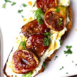 side angular shot of roasted fig toast served on a white platter.
