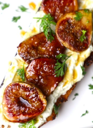 side angular shot of roasted fig toast served on a white platter.