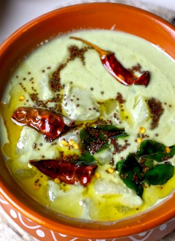 side aerial shot of majjige huli served in an earthen pot.