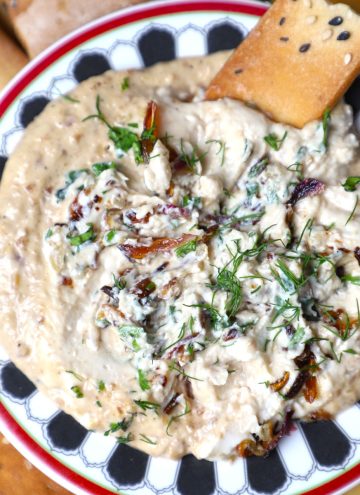 aerial shot of caramelized onion dip served with crackers.