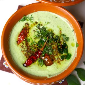 side close up shot of cucumber tambuli served in an earthern pot.