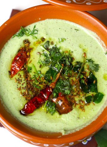 side close up shot of cucumber tambuli served in an earthern pot.