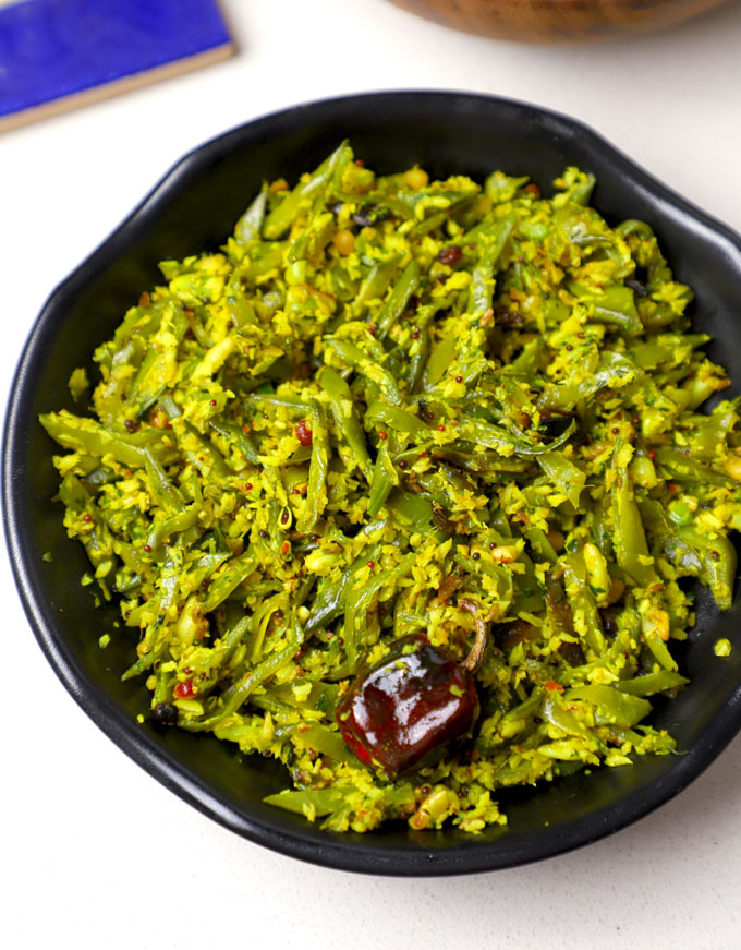 side close up shot of avarakkai poriyal served in a black bowl.