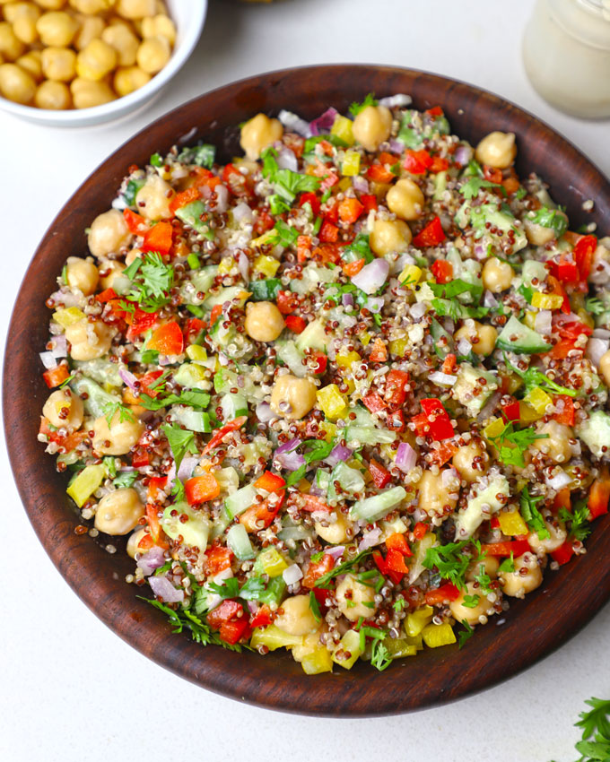 aerial close up shot of quinoa chickpea salad served in a wooden bowl.
