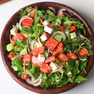 aerial shot of watermelon salad served in a wooden bowl.