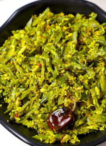 aerial shot of avarakkai poriyal served in a black bowl.