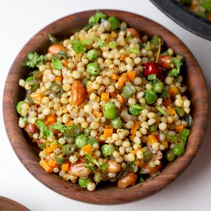 aerial shot of jowar upma served in a wooden bowl.