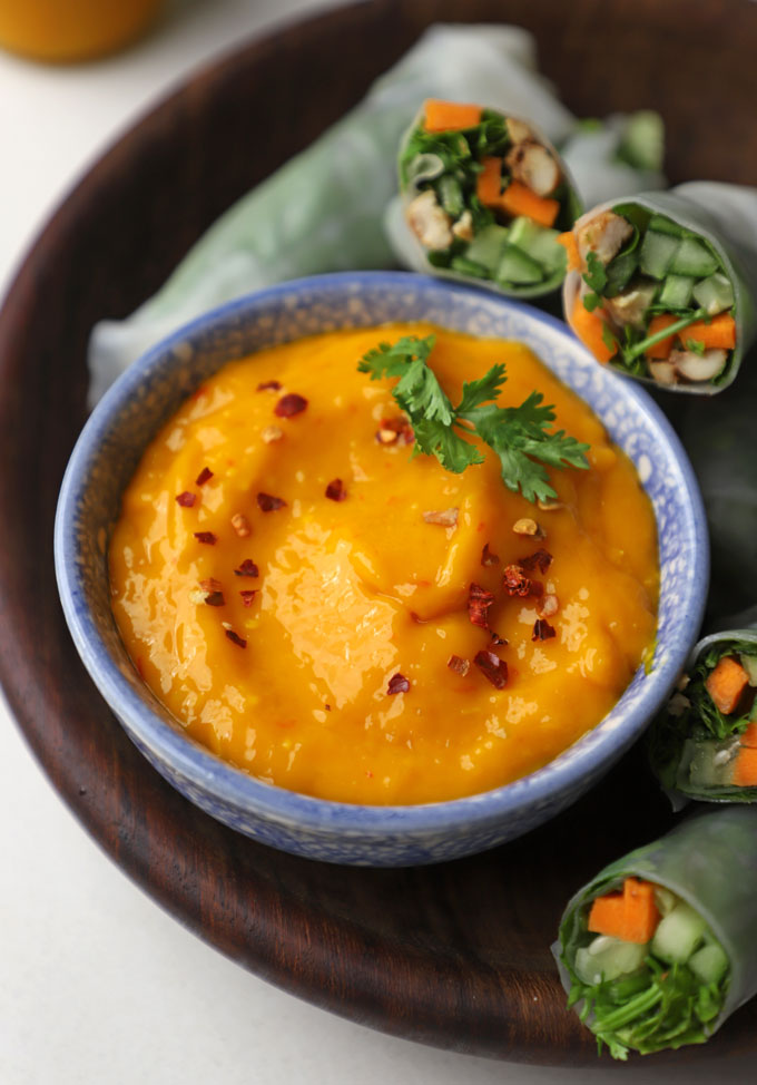 side angular shot of mango chilli sauce served in a blue ceramic bowl.